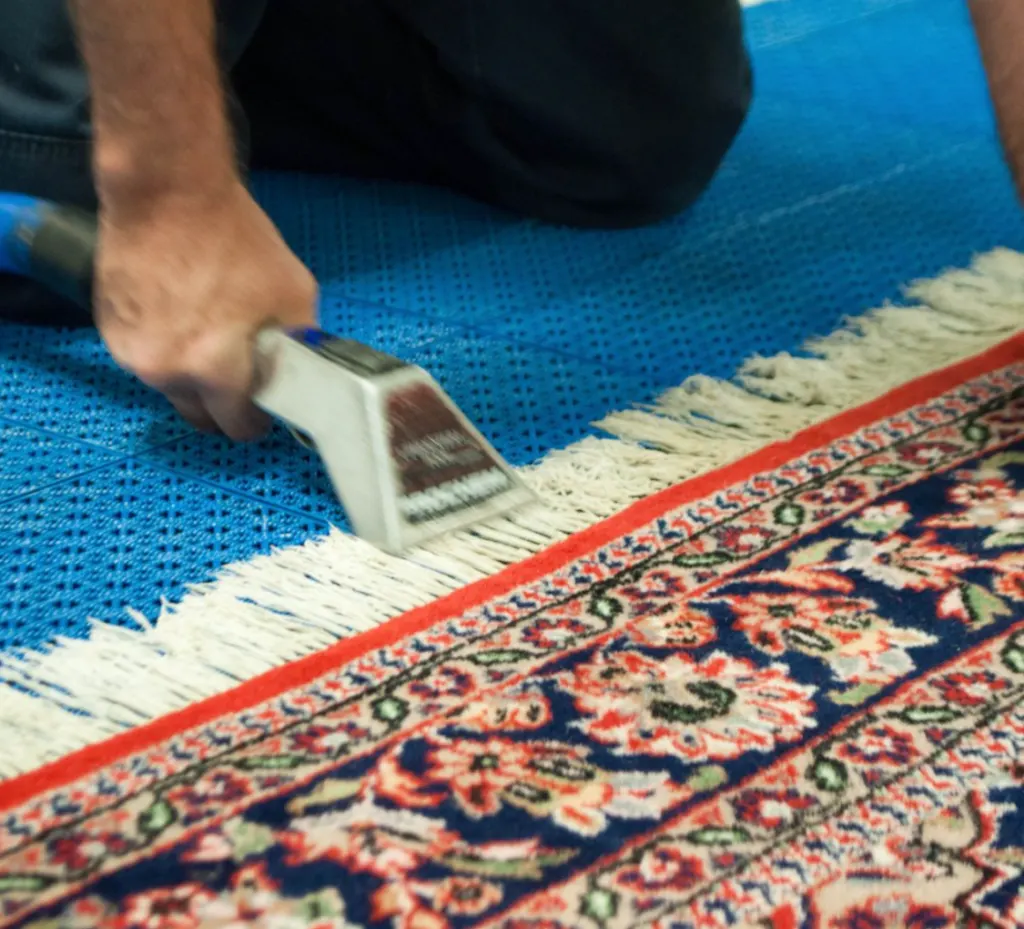 An oriental rug fringe being cleaned by hand at the Bear Carpet Care facility